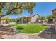 Spacious backyard with manicured lawn, rock landscaping, patio, and exterior view of the home at 8325 Villa De Medici St, Las Vegas, NV 89131