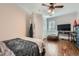 Comfortable bedroom with hardwood floors, a ceiling fan, a large window with shutters, and modern decor at 8325 Villa De Medici St, Las Vegas, NV 89131