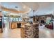 Open kitchen with wooden cabinets, granite counters, and a stone accent wall flowing into the living room at 8325 Villa De Medici St, Las Vegas, NV 89131