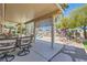 Relaxing covered patio with elegant dining set overlooking the pool and landscaped backyard at 8325 Villa De Medici St, Las Vegas, NV 89131