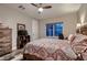 Bedroom features a ceiling fan, a view of the neighborhood, and rustic furniture at 8705 Killians Greens Dr, Las Vegas, NV 89131