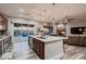 Gourmet kitchen boasts granite counters, stainless appliances, and an island that opens to the living room and backyard pool at 8705 Killians Greens Dr, Las Vegas, NV 89131