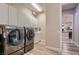 Bright laundry room with modern washer and dryer and ample cabinet space at 8705 Killians Greens Dr, Las Vegas, NV 89131