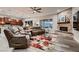 The expansive living room offers a brick fireplace, large windows, and an open floorplan to the kitchen area at 8705 Killians Greens Dr, Las Vegas, NV 89131