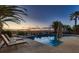 Relaxing backyard with a large pool, jacuzzi, and lounge chairs under swaying palms at 8705 Killians Greens Dr, Las Vegas, NV 89131