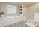 A modern bathroom featuring a soaking tub, a glass-enclosed shower, and stylish tile flooring at 881 Cherry Glen Pl, Las Vegas, NV 89138
