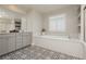 An elegant bathroom featuring a soaking tub, double vanity, and stylish tile flooring at 881 Cherry Glen Pl, Las Vegas, NV 89138