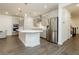 Modern kitchen with stainless steel refrigerator, island with quartz countertop, and gray cabinetry at 881 Cherry Glen Pl, Las Vegas, NV 89138