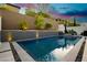 Backyard showcasing a sparkling pool and landscape with a dramatic dusk sky at 881 Cherry Glen Pl, Las Vegas, NV 89138