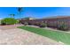 Landscaped backyard featuring brick, gravel, artificial grass, and plants at 9243 White Waterfall Ave, Las Vegas, NV 89149