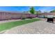 Backyard featuring brick patio, artificial grass, plants and bushes at 9243 White Waterfall Ave, Las Vegas, NV 89149