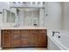 Bathroom with a double sink vanity, granite countertop, and a whirlpool bathtub at 9243 White Waterfall Ave, Las Vegas, NV 89149