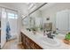 Bathroom with a double sink vanity, granite countertop, and decorative flowers at 9243 White Waterfall Ave, Las Vegas, NV 89149
