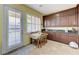 Kitchen space featuring wooden table, stone counter tops, cabinets and door to patio at 9243 White Waterfall Ave, Las Vegas, NV 89149