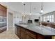 Spacious kitchen with granite countertops, center island, and open to living area at 9243 White Waterfall Ave, Las Vegas, NV 89149