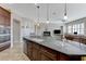 Open kitchen and living space boasts an oversized island with granite countertop at 9243 White Waterfall Ave, Las Vegas, NV 89149