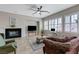 Spacious living room with a fireplace, ceiling fan, and natural light at 9243 White Waterfall Ave, Las Vegas, NV 89149