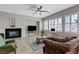 Bright living room with a ceiling fan, fireplace, and windows bringing in lots of natural light at 9243 White Waterfall Ave, Las Vegas, NV 89149