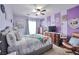 Inviting bedroom featuring neutral carpet, ceiling fan, and an accent wall painted in shades of light and dark purple at 9412 Jewel Lake Ave, Las Vegas, NV 89166