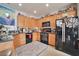 Well-lit kitchen with ample wooden cabinets, modern black appliances, and a granite countertop, ready for cooking at 9412 Jewel Lake Ave, Las Vegas, NV 89166