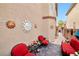 Cozy patio space adorned with sun-shaped wall decor and inviting red seating, perfect for outdoor relaxation at 9412 Jewel Lake Ave, Las Vegas, NV 89166