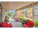 Relaxing covered patio with an assortment of seating, lush plants, and whimsical decorations for outdoor enjoyment at 9412 Jewel Lake Ave, Las Vegas, NV 89166