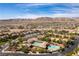 Expansive aerial view of community showcasing a pool and surrounded by houses with mountain views at 9465 Perennial View Ave, Las Vegas, NV 89148