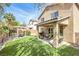 Lush backyard featuring artificial grass, a covered patio, and a charming pergola with outdoor seating at 9465 Perennial View Ave, Las Vegas, NV 89148