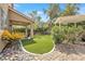 An inviting backyard boasts lush artificial grass, a covered patio, and a charming pergola at 9465 Perennial View Ave, Las Vegas, NV 89148