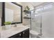 Bathroom featuring vanity with framed mirror and tiled walk-in shower with glass door at 9465 Perennial View Ave, Las Vegas, NV 89148
