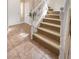 Inviting entryway with tile flooring leads to a carpeted staircase with white railing, creating an elegant and welcoming ambiance at 9465 Perennial View Ave, Las Vegas, NV 89148