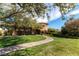 A well maintained front yard with mature trees, a curved walkway, and a landscaped garden at 9465 Perennial View Ave, Las Vegas, NV 89148