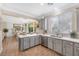 Open kitchen featuring gray cabinets, stainless steel appliances, and a seamless view into the adjacent dining and living areas at 9465 Perennial View Ave, Las Vegas, NV 89148