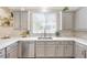 Bright kitchen featuring stainless steel appliances, gray cabinetry, light countertops, and a well-lit, functional workspace at 9465 Perennial View Ave, Las Vegas, NV 89148