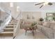 Comfortable living room boasts a large sectional sofa, soft rug, and easy access to the staircase at 9465 Perennial View Ave, Las Vegas, NV 89148