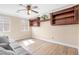 Bright living room with wood floors, built-in shelves, and a ceiling fan at 9465 Perennial View Ave, Las Vegas, NV 89148