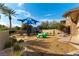 A community playground features play structures, mature trees, and play area for children at 9465 Perennial View Ave, Las Vegas, NV 89148
