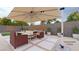 Staged backyard with an umbrella, outdoor seating, and a modern water feature at 9732 Abel Cliff St, Las Vegas, NV 89143