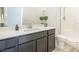 Bathroom vanity with double sink and gray cabinetry, quartz countertop, and adjacent glass-enclosed shower at 9732 Abel Cliff St, Las Vegas, NV 89143
