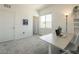 Bright bedroom featuring plush carpet, white walls, and a work desk setup at 9732 Abel Cliff St, Las Vegas, NV 89143