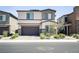 Modern two story home with a neutral exterior, stone accents, desert landscaping and covered entry at 9732 Abel Cliff St, Las Vegas, NV 89143