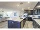 Open-concept kitchen featuring an island, stainless steel appliances, and hardwood flooring at 9732 Abel Cliff St, Las Vegas, NV 89143