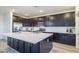 Contemporary kitchen featuring a large island, stainless steel appliances, and sleek dark cabinetry at 9732 Abel Cliff St, Las Vegas, NV 89143