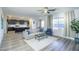 Open-concept living room with modern furniture, lots of natural light, and kitchen in background at 9732 Abel Cliff St, Las Vegas, NV 89143