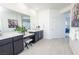 Bright main bathroom with dual sinks, large mirror, neutral decor, and tile flooring at 9732 Abel Cliff St, Las Vegas, NV 89143