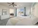 Bright main bedroom with slider to balcony, ceiling fan, and open doorway to bathroom at 9732 Abel Cliff St, Las Vegas, NV 89143