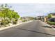 Scenic street view of neighborhood featuring landscaped medians, mature trees, and well-maintained homes at 9732 Abel Cliff St, Las Vegas, NV 89143