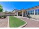 Landscaped backyard featuring artificial turf, stone landscaping, and covered patio at , Las Vegas, NV 89149