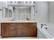 Bright bathroom featuring double vanity with dark wood cabinets and a large soaking tub at , Las Vegas, NV 89149