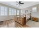 Cozy bedroom featuring hardwood floors, a ceiling fan, and large windows with bright white shutters at , Las Vegas, NV 89149